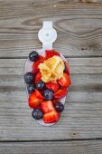 Waffle bites with fresh berries on a large enamel spoon