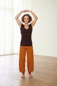 Carrying the sky (qigong) – Step 3: hands above head, fingers linked