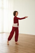 Carrying the ball in front of shoulders (qigong) – Step 4: raise right hand, stretch rear leg