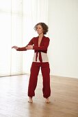 Twisting hips and jabbing with hands (qigong) – Step 2: twist left, raise both arms