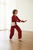 Pushing the water and assisting the waves (qigong) – Step 5: weight on right leg, lower arms