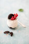 Cheesecake with chocolate biscuits and redcurrants in a jar