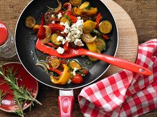 Colourful fried peppers and courgettes with sheep's cheese