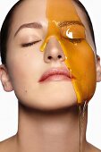 Honey flowing over a woman's face