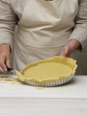 Cut off the edge of the baking tin lined with shortcrust pastry