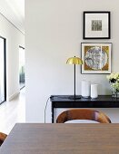 View of console table and pictures seen over dining table