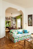 Floral sofa in front of open doorway leading into dining room