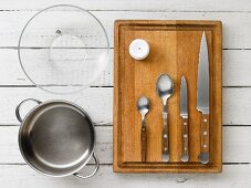Kitchen utensils: a pot, a glass bowl, a egg piercer and cutlery