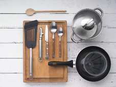 Various kitchen utensils: a pot, a pan, cutlery, a peeler and a spatula