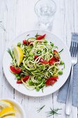 Courgette spaghetti with tomatoes and peas