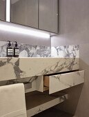 Custom marble washstand with drawer below mirrored cabinet with indirect lighting