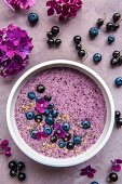 A smoothie bowl with blueberries, blackcurrants and seeds