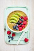 A smoothie bowl with matcha, kiwi and berries