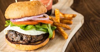 A burger with a fried egg and chips