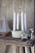 Candle arrangement, stylised Christmas tree, silver star and silver bell on wooden bench