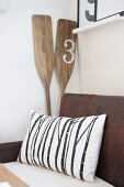 Cushion on vintage bench and wooden oars in corner