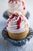 A cupcake with strawberry cream and strawberry sauce