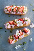Eclairs with strawberries, cream and pistachios