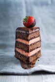 A piece of chocolate sponge cake filled with strawberry buttercream