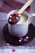 A chocolate spoon balanced on a cup of milk (Valentine's Day)