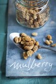 Dried white mulberries in a storage jar and on a spoon