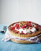 Pecan pie with cream, raspberries and pomegranate seeds