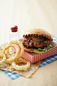 An all-American burger with gherkins and onion rings