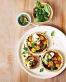 Tartlets with caramelised tomatoes, pesto, cream cheese and basil