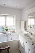 Bathtub and washstand with marble counter in bathroom