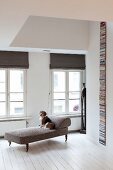 White wooden floor and dog on antique chaise longue in renovated period apartment