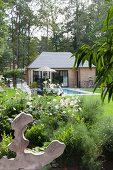 Kleines Haus mit Pool im sommerlichen Garten mit Bäumen