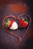 Strawberries dipped in chocolate framed by a melted chocolate heart