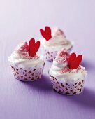 Cupcakes mit Tortenpapier und roten Herzen