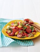 Gemischter Tomatensalat mit roten Zwiebeln und Basilikum