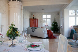 Tiled stove and bay window in living room seen across dining table