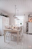 Set dining table in white, cottage-style kitchen-dining room