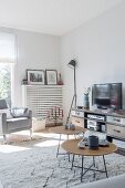 Filigrane Couchtische mit Baumscheiben vor TV-Möbel und Fernseher