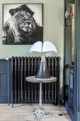 Picture of lion above ornate radiator behind table lamp on side table
