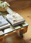 Books and tealights on pallet table with castors and glass top