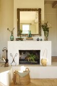 Gilt-framed mirror above open fireplace on masonry plinth