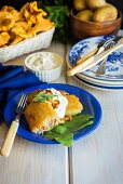 Fried potato dumplings with a minced meat & chanterelle mushroom filling on a bed of spinach leaves with sour cream