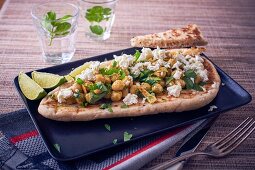 A naan bread with chickpeas and feta