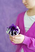 Child holding posy of violas