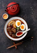 Asian noodles in broth with slow cooked Beef and Egg on dark background