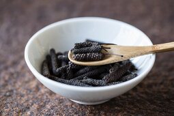 Long pepper with a wooden spoon in a bowl