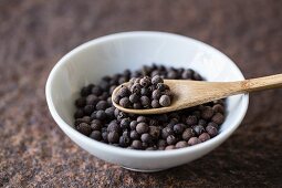 Allspice with a wooden spoon in a bowl