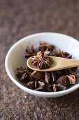 Star anise with a wooden spoon in a bowl