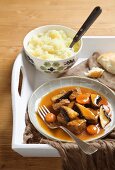 Beef stew with mushrooms and dark beer sauce served with a side of mashed potato