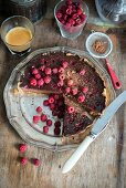 Chocolate tart with chocolate filling and raspberries, decorated with fresh raspberries, sliced