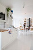 Blick aus der weißen Küche in den Wohnraum mit Esstisch